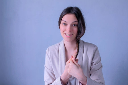 Beauty blogger talking about hairs care and problems recording video looking at camera. Young woman...
