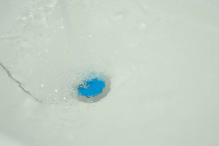 Clear water is running in bathtub with drain closed stopper, preparing for bathing. Bath fills with water. Preparation for taking a bath. Nobody in frame.の写真素材