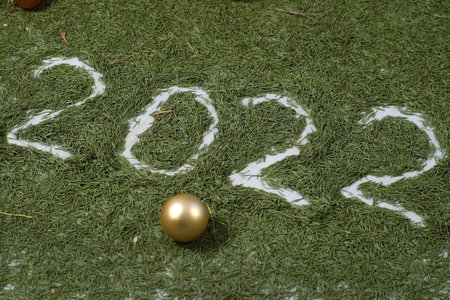 New Year background with natural fir needles, inscription 2022 and golden balls. Christmas, festive backdrop. Celebrating, preparing to winter holidays.の写真素材