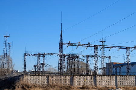 High voltage electric tower on sunny sky background in village. Transmission power line. Parts of...