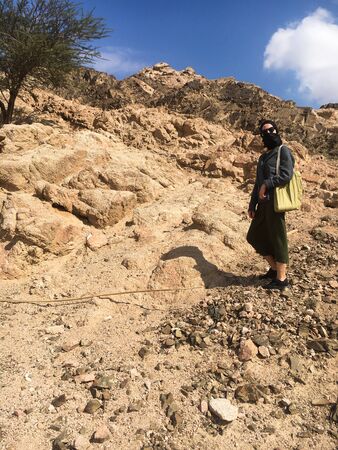 A girl in a black veil stands on a mountain and looks at the camera. Tourism. Jordan, Aqaba.のeditorial素材