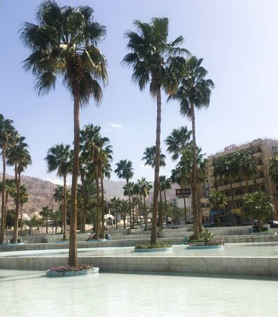 Palm trees around the fountain against the backdrop of a hotel. Arab country. Jordan, Aqaba.のeditorial素材