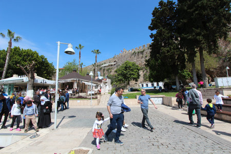 People walk along the square near the old castle near the port. Antalya, Old city. Tourism.のeditorial素材