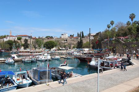 The shore of the tourist port. View of the Mediterranean Sea, ships and yachts. People walk along the shore. Antalya, Turkey.のeditorial素材