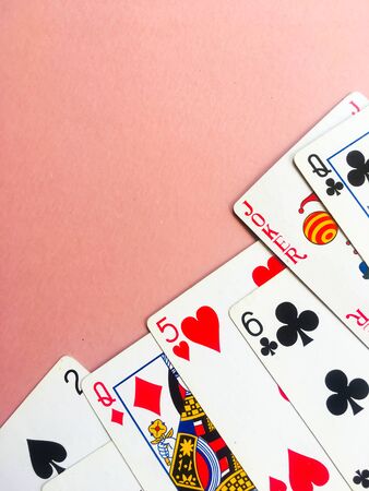 Cards for playing poker lie at the bottom of a pink background. Place for text. Gambling.のeditorial素材