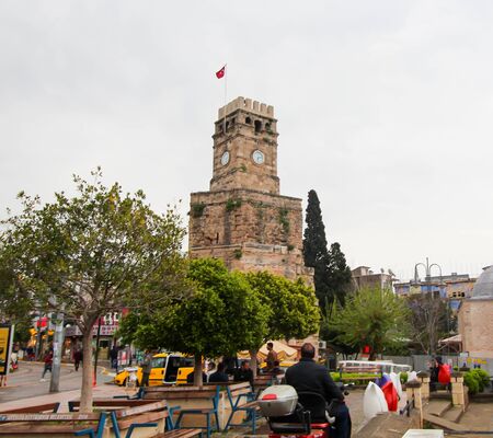 Clock Tower, Turkish flag at the top. People are walking in the square. Antalya, Turkey, April 6, 2019.のeditorial素材