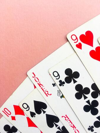 Cards for playing poker lie in the coner of a pink background. Place for text. Gambling.のeditorial素材