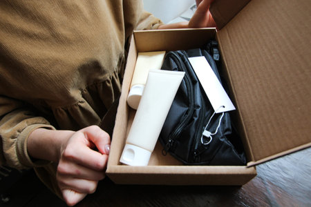 The girl in the hands holds a box. There lies cosmetics and a bag. Preset
