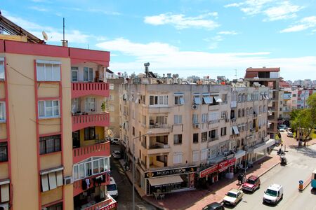 View of the city street, residential buildings and shops. On the roof there are solar panels, tanks for heating water. Antalya, Turkey, April 6, 2019.のeditorial素材