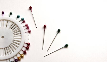 Set of sewing pins with colored beads in an white organizer on a white isolated background. Copy space.の写真素材
