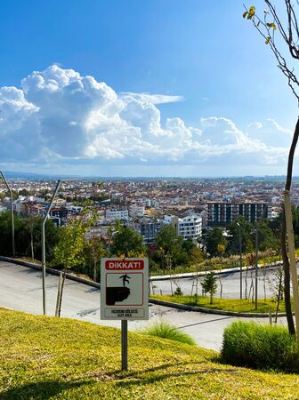 View of the city and the road from the hill. Ahead of the plate: danger. Travel route. Turkey. Autumn. November 12th 2019.の写真素材
