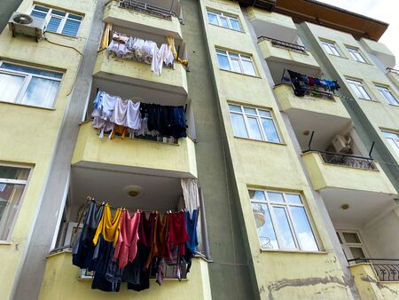 Clothes are dried on a bolcon. Exterior of a residential building. On the facade of the house is air conditioning. Turkey. Old building.の写真素材