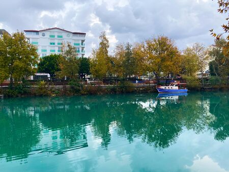 On the lake a boat against the background of houses and trees. Turkey. Autumn.の写真素材
