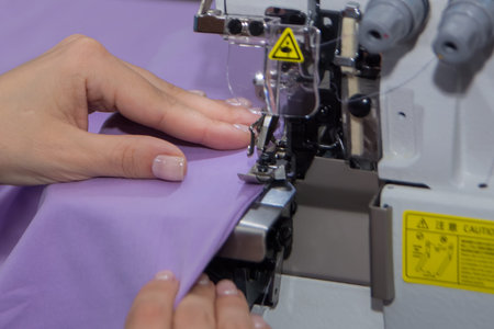 seamstress sews fabric on a sewing machine