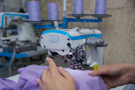 seamstress sews fabric on a sewing machineの写真素材