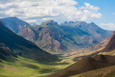 The green slopes of the mountains, the shadow of the clouds lies on the ground.の写真素材
