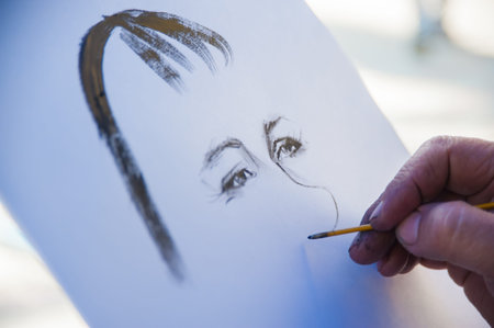 the artist's hand paints a portrait of a man