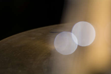 Drum cymbal in blur, reflections from cymbals give golden bokeh.の写真素材