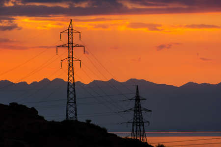 Lines of high-voltage wires at sunset.の写真素材