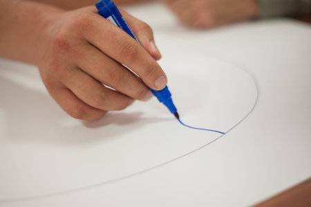 Hand holding a felt-tip pen, a person draws a picture