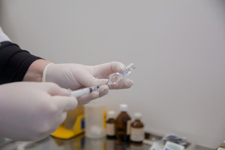 the doctor prepares the injection, draws liquid for injection into the syringeの写真素材