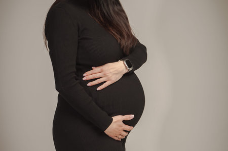 pregnant woman with a big belly posing in a photo studio