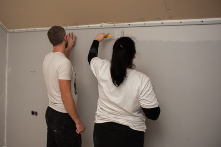 Young couple, man and woman pasting wallpaperの写真素材