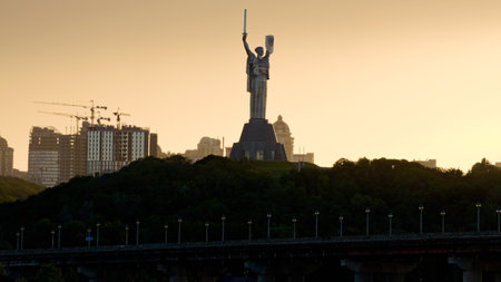Kyiv, Ukraine-July 17,2022: Famous Motherland Monument (Rodina mother) during summer sunset. Unfinished multi-story apartment buildings in the background.のeditorial素材