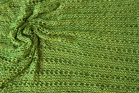 Sparkling green knit fabric with twisted folds on the left side of the frame.の写真素材