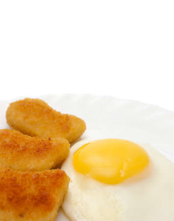 Fried egg sunny side up and nuggets on plate copy space isolated on whiteの写真素材