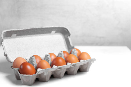 chicken egg in a cardboard box on a white table