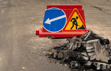 road sign, detour, road repair on the background of the road and broken asphalt, close upの写真素材