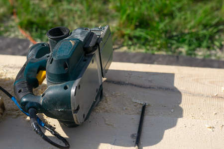 electric woodworking tools lying on the lumber outdoorsの写真素材