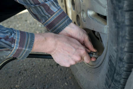 man pumps the car wheelの写真素材