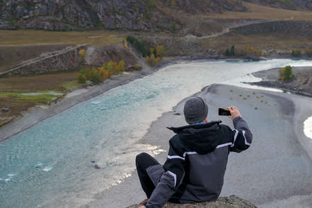 tourist sitting on a hill takes picturesの写真素材