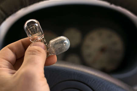 new and burnt out light bulbの写真素材