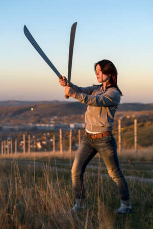 Girl on a high mountain trains with a macheteの写真素材