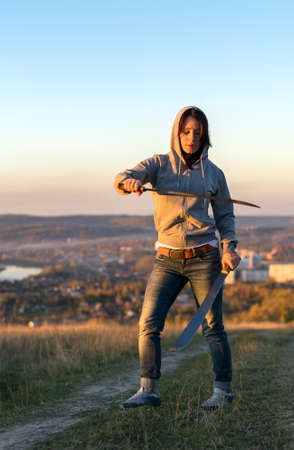 Girl on a high mountain trains with a macheteの写真素材