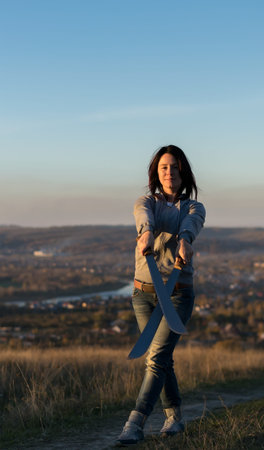 Girl on a high mountain trains with a machete