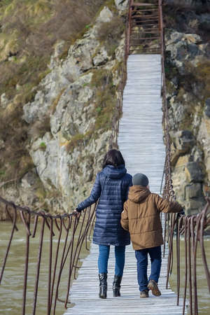 a mother with a child, walking on a wooden bridgeの写真素材