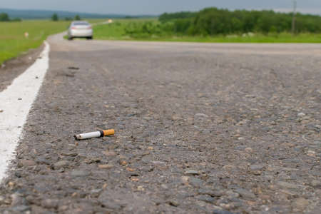 View of cigarette lying on the asphaltの写真素材