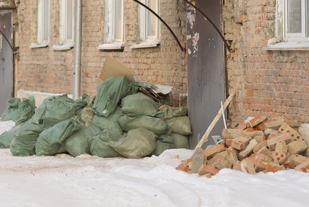 construction debris in bags near the front door of an old apartment building