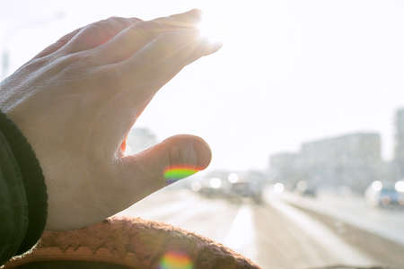 The hand of the driver of the car covers the sunlightの写真素材