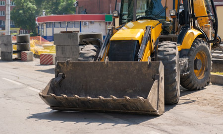 excavator on a city street where the road is being repaired