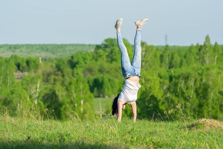 girl stands upside down in nature