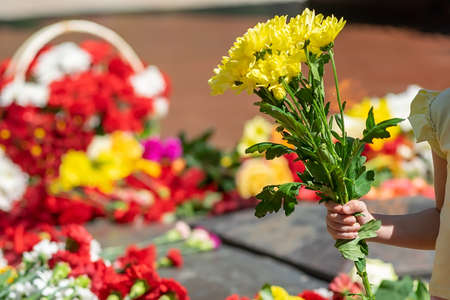 people lay flowers to the eternal flame at the memorial of memoryの写真素材