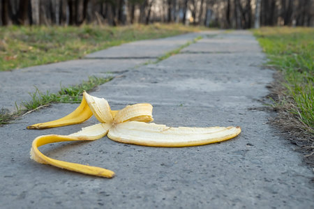 a banana peel lies on a footpathの写真素材