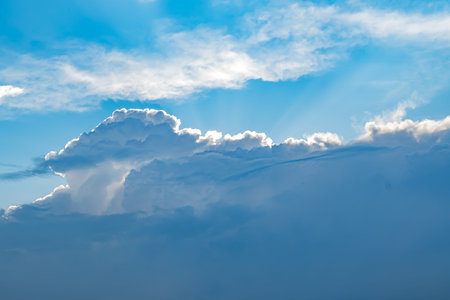 view of the sky with Cumulus clouds with the light of the sun rays coming from the clouds
