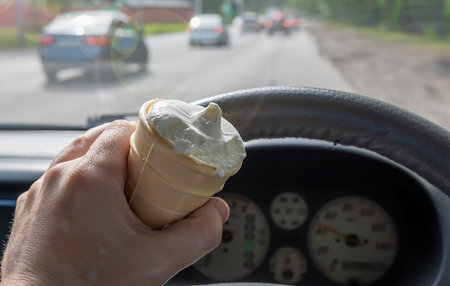 ice cream in the hand of the driver of the car