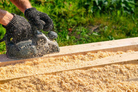 the hands of a person, a worker, a carpenter hold an electric planeの写真素材